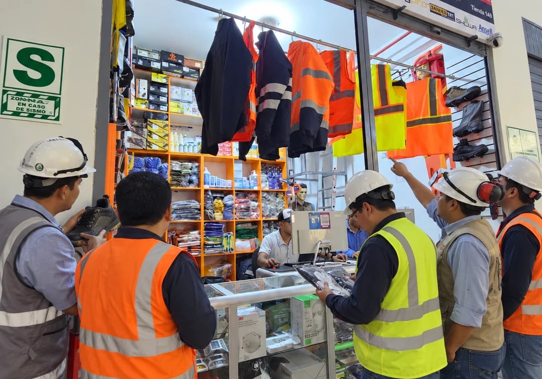 Clientes con casco y chaleco atendidos en el mostrador de la tienda de FAGY Perú